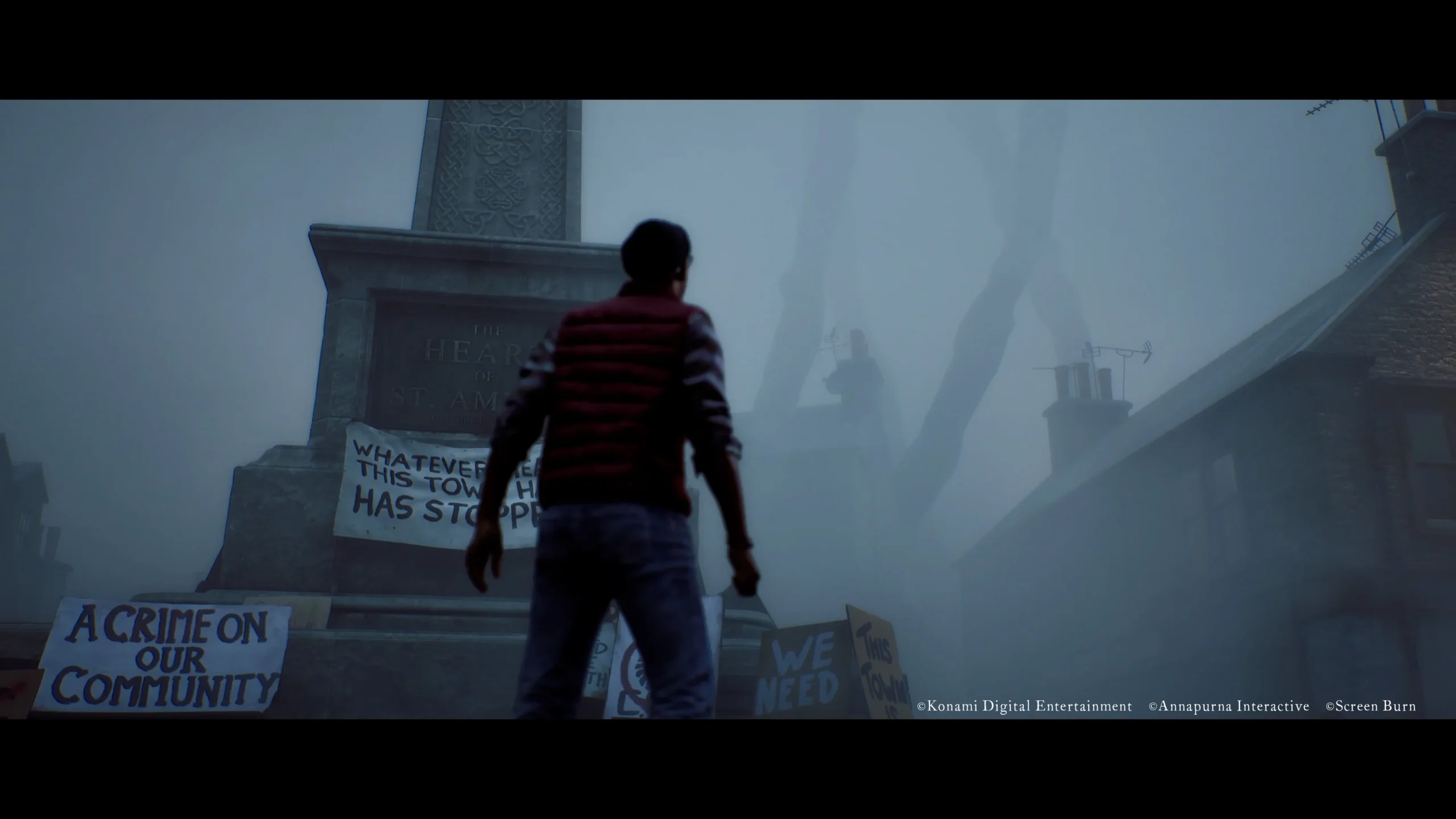 Simon observa un monumento cubierto de pancartas de protesta en una escena de Silent Hill: Townfall